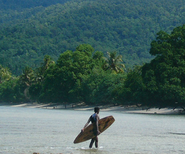 surfer walking to shore with board in hand